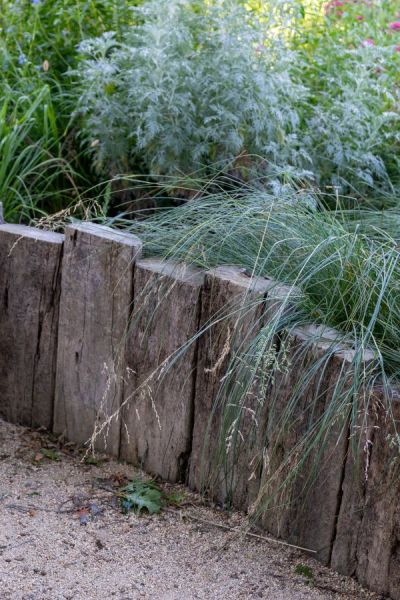 Some soil has been mounded up to give the border some height. This is edged with chunky rustic timbers.