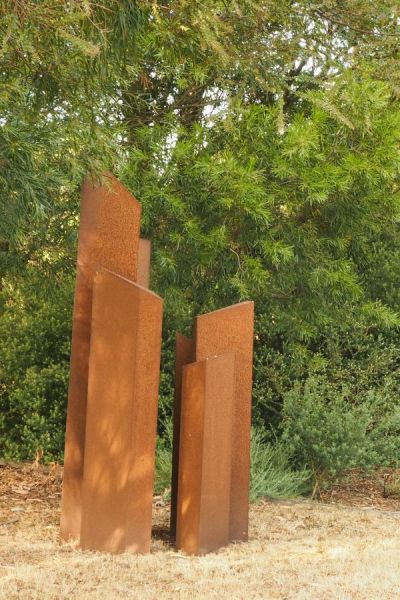 A garden sculpture made of cut pieces of corten steel. 