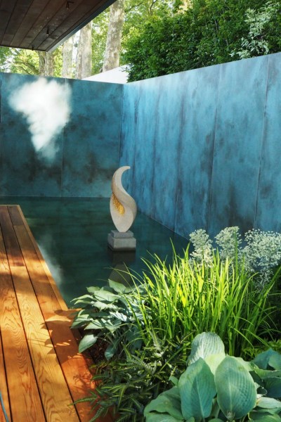 A garden pond going right up to the wall of an urban garden #backyard #gardendesign