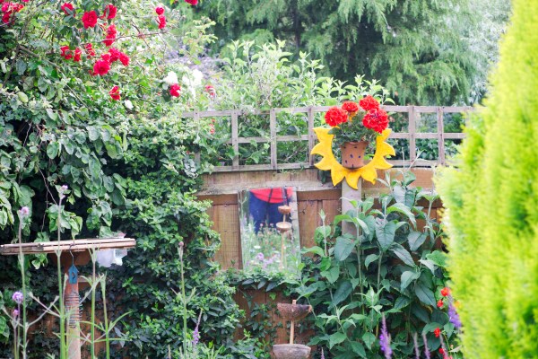 Bird feeders and garden art in a small garden