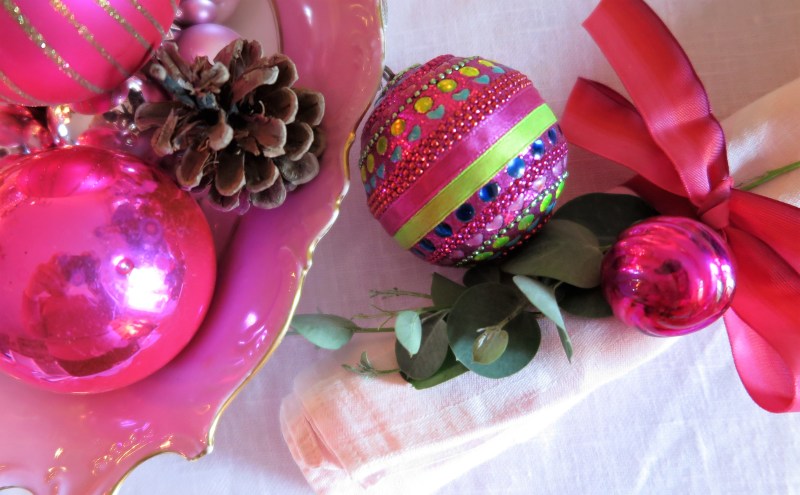 Tie napkins with baubles and ribbon for a jewel pink look