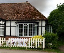 Jam jar flowers hung on a picket fence